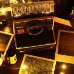 Photos de voyage imprimées posées sur une table autour d’un appareil photo instantané