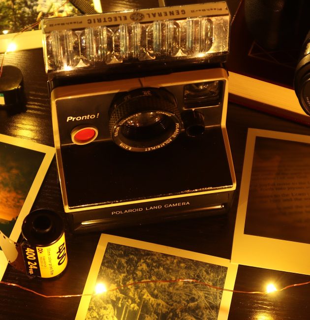 Photos de voyage imprimées posées sur une table autour d’un appareil photo instantané